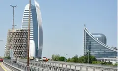 Модерни стъклени офис сгради край надлез на Цариградско шосе в София, с камиони по пътя